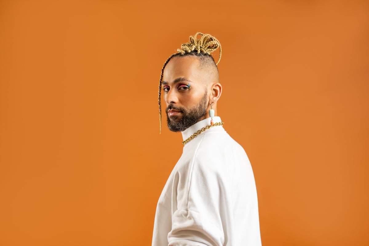 Queer Person with Makeup on Orange Background